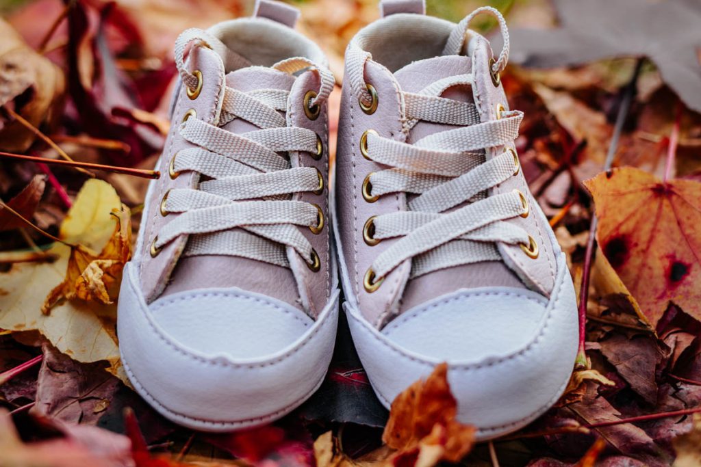 Fotógrafa de gestante na rua do Outono em Curitiba - sapatinho de bebê nas folhas vermelhas da rua do Outono no Bairro Mossunguê.