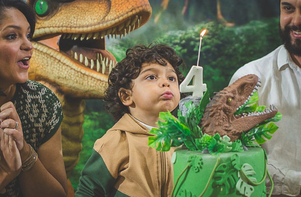 Fotografia de festa infantil - hora do parabéns - menino soprando a vela de aniversário em Curitiba