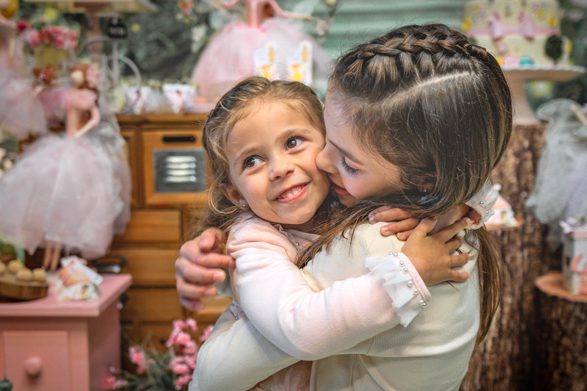 Festa infantil de 4 anos - irmãs se abraçando em fotografia de festa infantil no Brigadeiro Buffet em Curitiba 