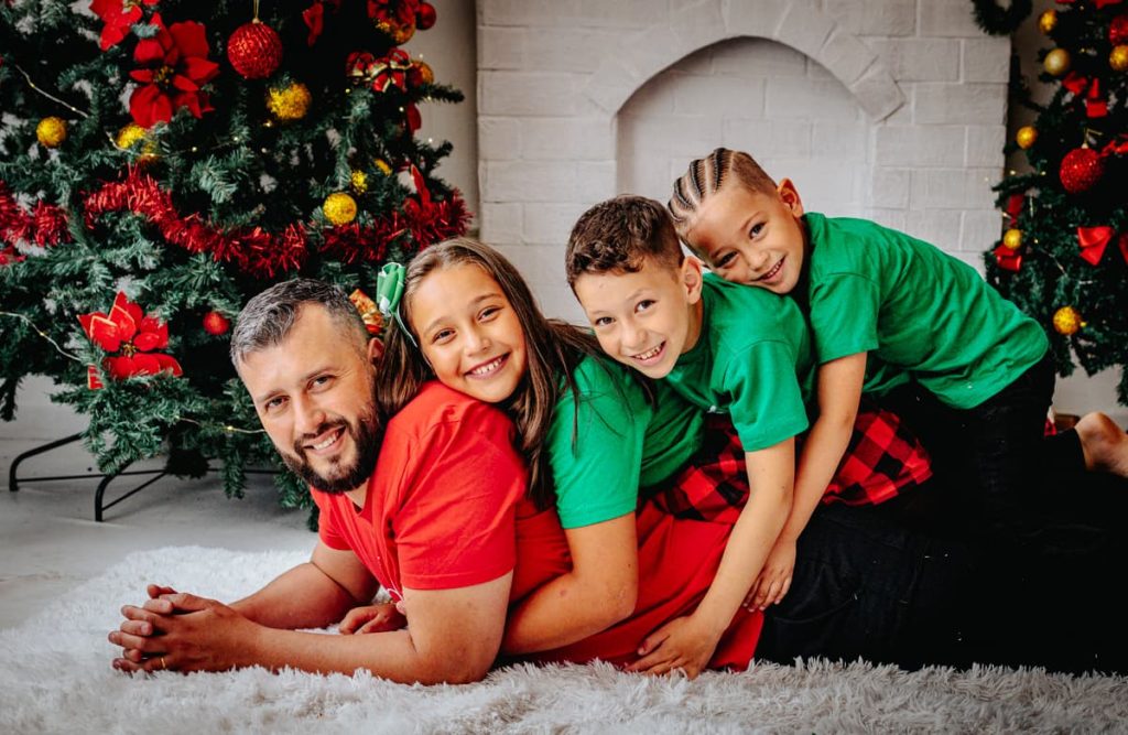 pai com filhos nas costas em foto divertida durante ensaio de natal em Curitiba
